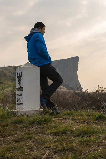 Young adventure traveler is hiking to the top of the mountain to see sunrise at Phu Chi Fa, The beautiful famous place to travel in Chiang Rai, Thailand.