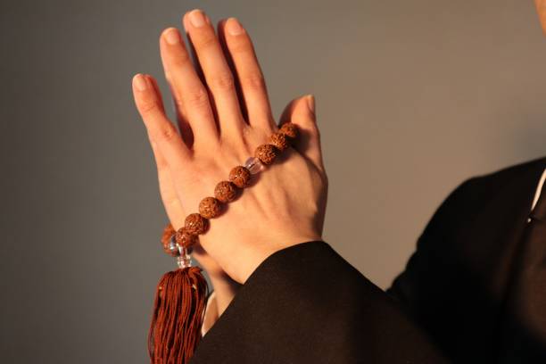 istock Person praying with beads 1643934633