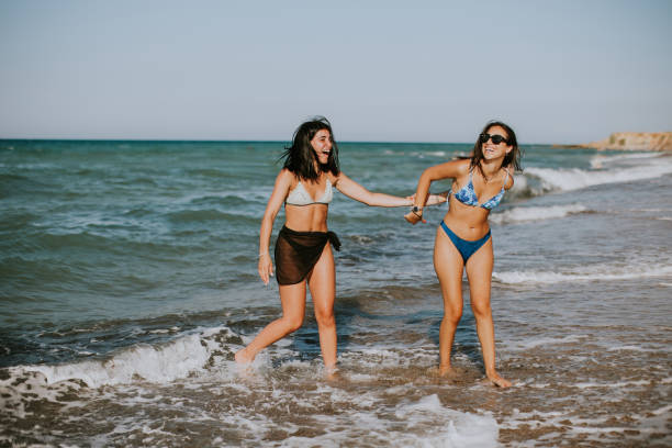 istock Two pretty young woman having fun on the seaside 1643936524
