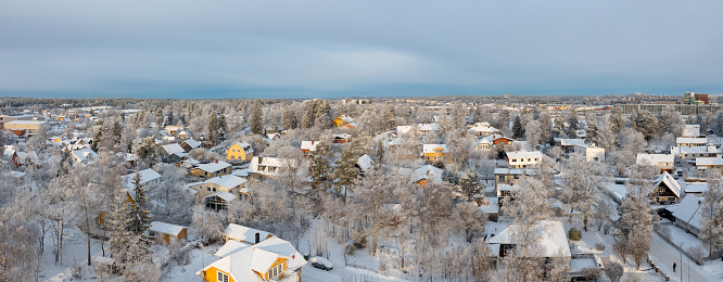 From the unique vantage point of a drone, a residential neighborhood is beautifully transformed. The aftermath of a recent snowstorm cloaks every street, rooftop, and tree in a pristine, white blanket. This aerial perspective offers a captivating glimpse of a winter wonderland, showcasing the area's tranquility and the enchanting beauty of the season.