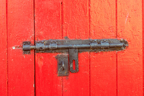 Unlocked steel bolt lock on a double door shed barn workshop