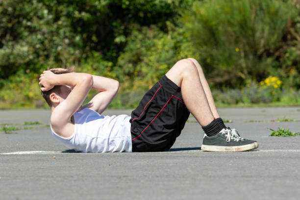 istock Teenage boy doing situps 1643944398