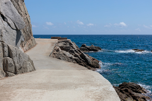 A tranquil coastal road meanders along the rugged coastline, offering a perfect backdrop for showcasing vehicles against the mesmerizing sea scenery.
