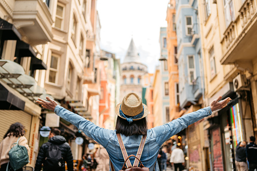 Beautiful young woman enjoying the view of the Galata Tower in Istanbul Turkey.