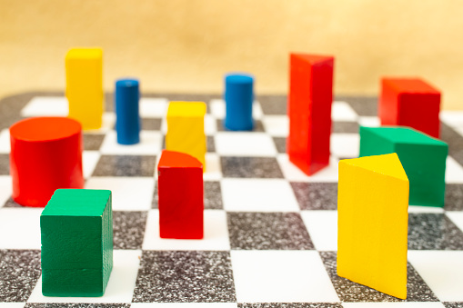 playing chess with colored wooden cubes, creative concept, soft focus close up