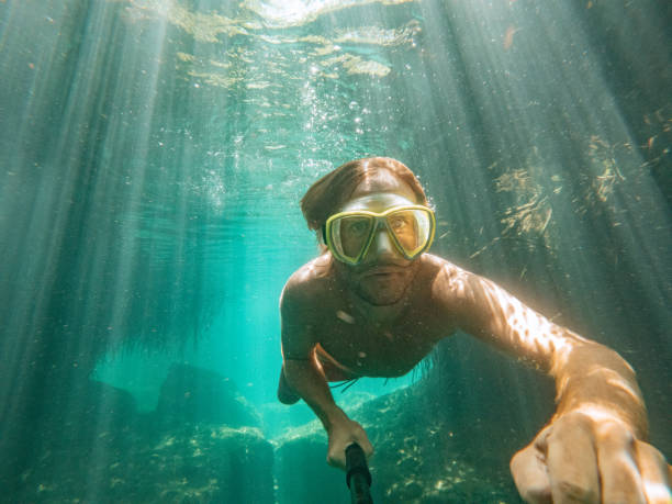 istock Man takes selfie underwater while swimming in a clear clean water 1643965356