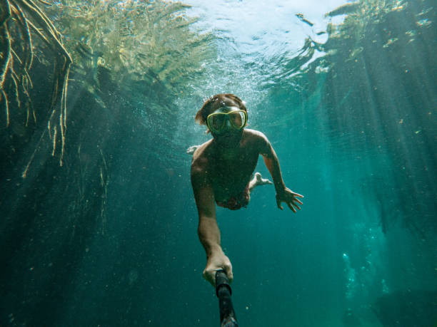istock Man takes selfie underwater while swimming in a clear clean water 1643965437
