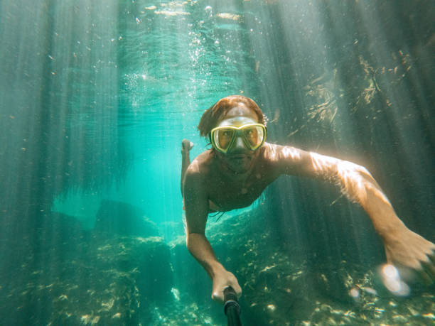 istock Man takes selfie underwater while swimming in a clear clean water 1643965460