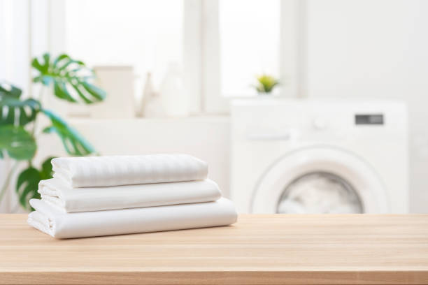 Stack of clean laundry bedding sheets on table in bathroom stock photo