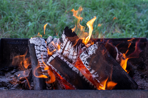 Wood burning with orange flames, soft focus close up