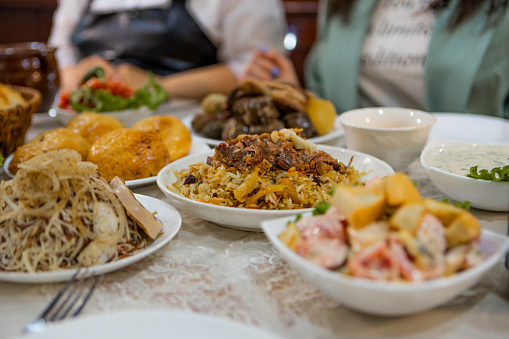 Assorted Uzbek food set, pilaf, samsa, lagman, manta, shurpa central asia food. Homemade Uzbek pilaf or plov from lamb served in cast iron cookware