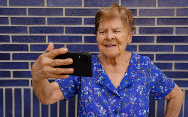 istock Happy old woman with smartphone having video call 1643968898