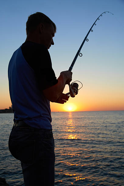 istock Fisherman fishes at the  sunset 164397471