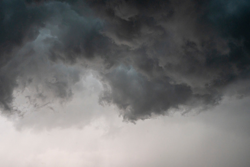 Storm clouds over Zwolle during a summer thunderstrom at the end of a warm and humid summer afternoon. A shelf cloud is seen from underneath with dramatic shaped clouds moving fast.