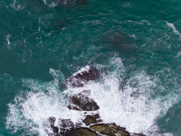 istock Waves crashing on seashore rocks,Top view sea surface waves background 1643980688