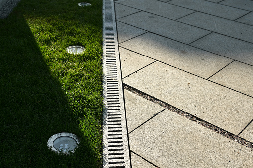 Concrete rain drain on the street in landscape design, drainage of rain underground sewerage system