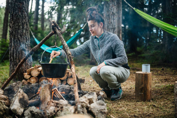 istock Woman cooking meal on the campfire. 1644005369