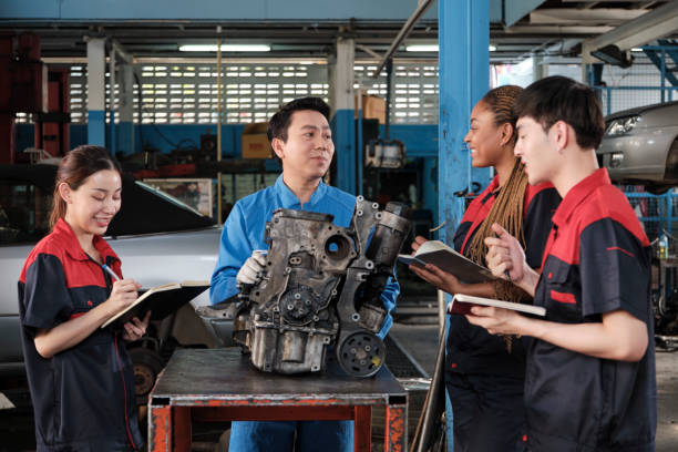 istock Supervisor engineer is teaching mechanic workers about car engines at a garage. 1644005704