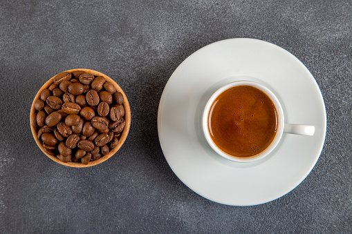 Coffee beans roasted with a cup of Turkish coffee on the black concrete floor