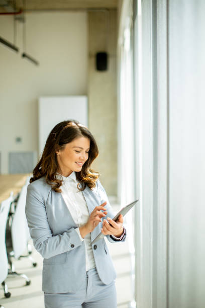 istock Young woman working on digital tablet by the office window 1644006216