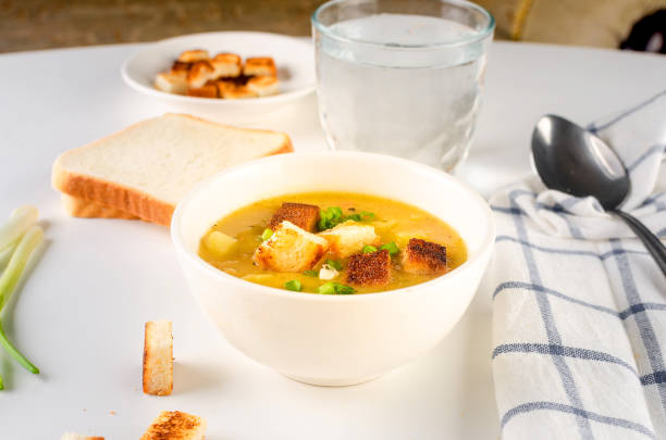 istock Split pea soup with croutons and green onion in a bowl on white table. 1644014881