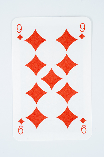 A macro photo of the Queen of Diamonds playing card, showing the texture of the card, set against a pale background.