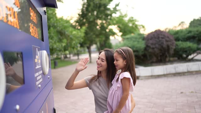 Mother teaching daughter about recycle Waste management