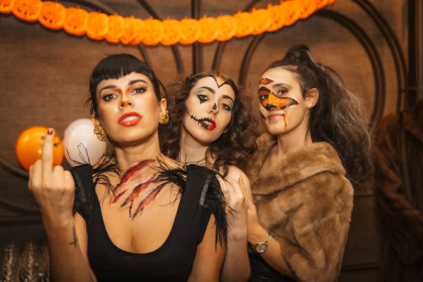 ハロウィーンパーティーでディスコナイトクラブの友人とカメラを見ている衣装を着た女性の友人 - music festival halloween vampire women ストックフォトと画像