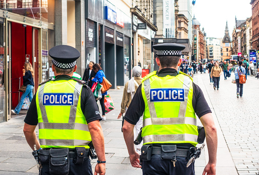 Glasgow, Scotland - A rear view of two police officers as they walk on Argyll street in Glasgow's city centre.