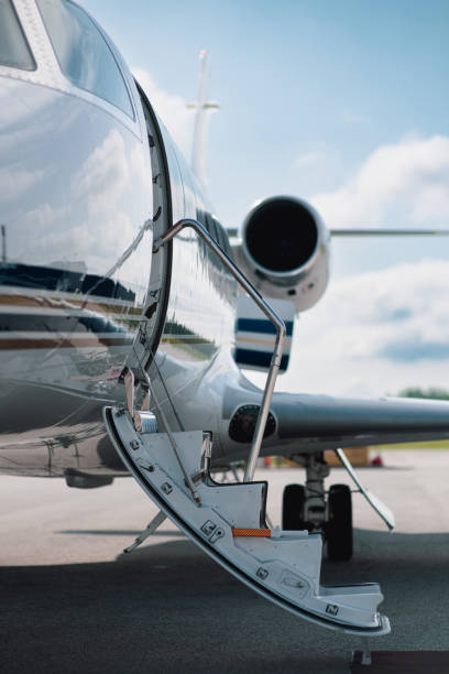 Lowered Boarding Stairs on a Small Private Jet Focus is on the lowered boarding stairs of a small private jet parked on the tarmac of a small airport. flight of steps stock pictures, royalty-free photos & images