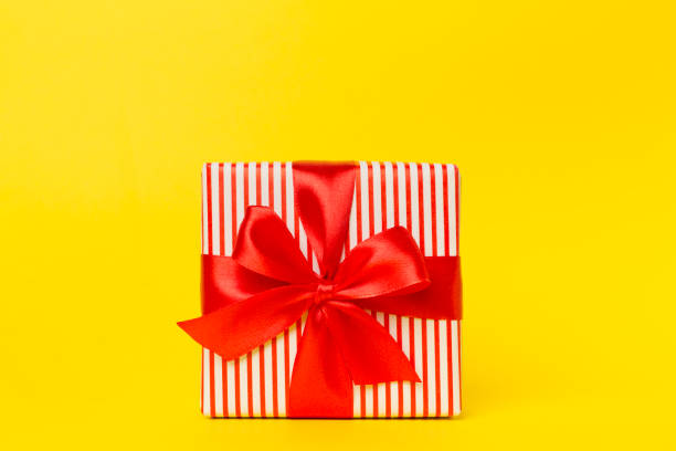 Gift box with red ribbon bow on color background