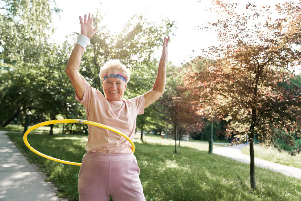 istock Senior woman exercising with plastic hula hoops ring in the park 1644109708