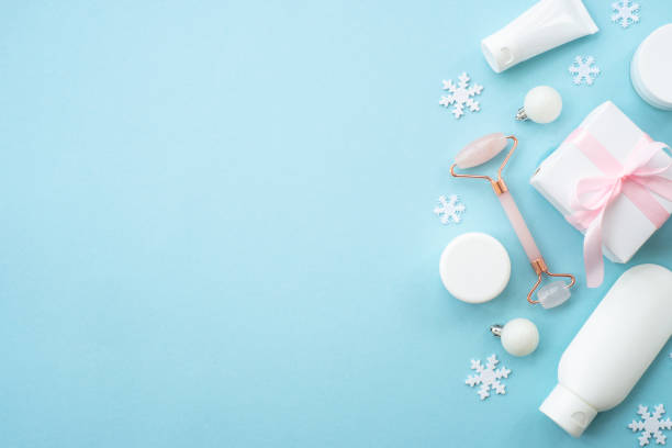 istock Natural winter cosmetic with holiday decorations and present box on blue background. 1644115212