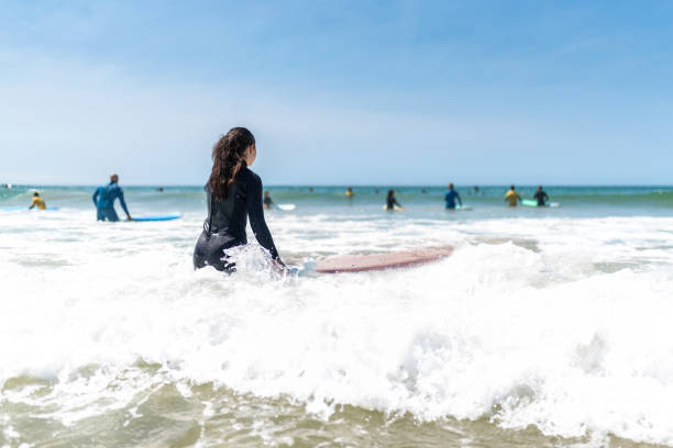 istock girl going with surfboard into the water 1644122385