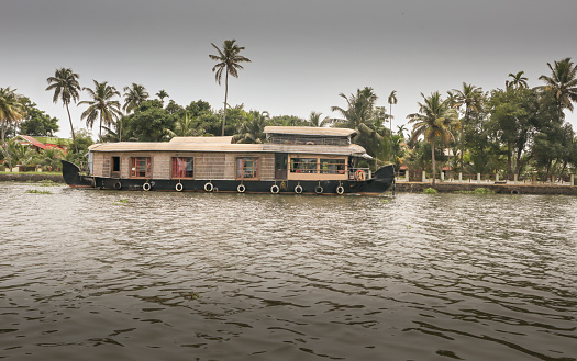 Kochi, Kerala, India-October 9 2022; An Engaging picture of a Landscape scenery in the Kerala backwaters with a traditional Tour House boat visiting the Kochi city in India.