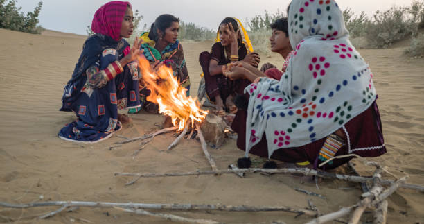 istock Indian kids setting up bonfire on sand dune 1644161828