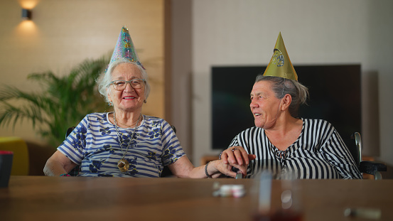 A portrait of two senior adult women friends during a birthday celebration.