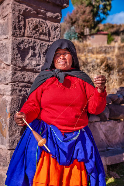 istock Woman spinning a wool by hand on Taquile Island, Peru 1644165599