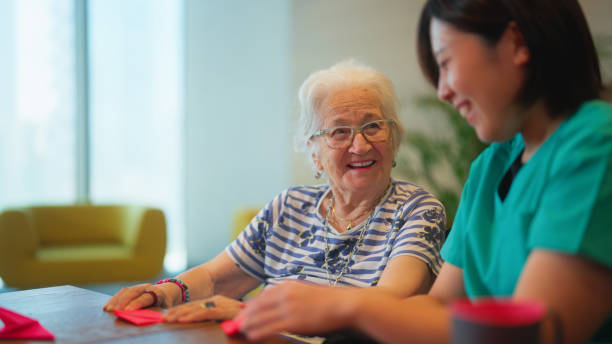 Senior woman learning making origami as for physiotherapy activity