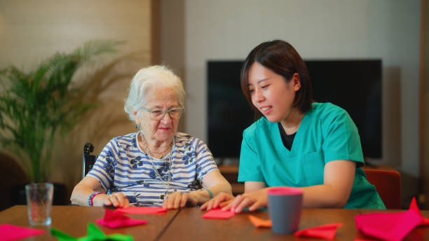 istock Senior woman learning making origami as for physiotherapy activity 1644169954