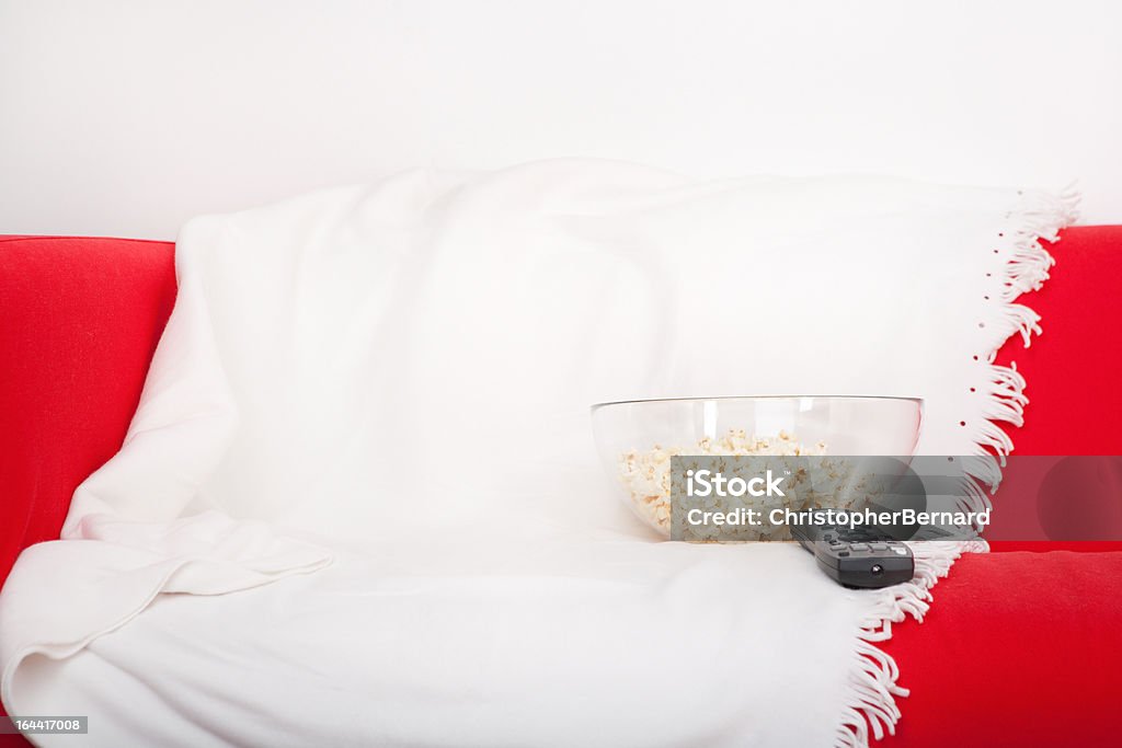 Ciotola di Popcorn sul divano e remota - Foto stock royalty-free di Coperta