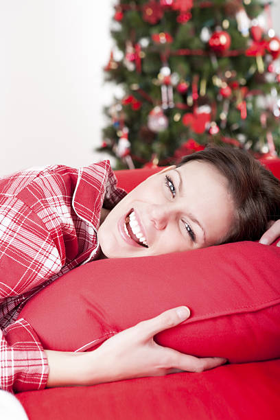 istock Christmas-Pretty young woman lying on couch 164418360