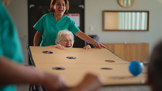 Two senior adult women are playing games as physiotherapy in a nursing home.