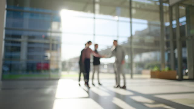 Business people, group handshake and blur in office introduction, welcome to hotel or lobby at sunset. Shaking hands, team and deal, b2b agreement or collaboration, thank you and partnership meeting