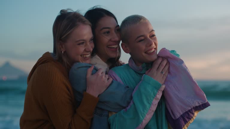 Beach, sunset and female friends hugging while on a seaside vacation, adventure or holiday. Nature, travel and gen z women bonding together at sunrise by ocean while on a tropical weekend trip.