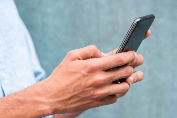 istock Close up of man hands using mobile phone 1644226482
