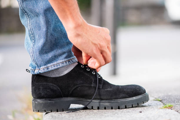 istock Man hand tying shoelace outside on the sidewalk 1644228152