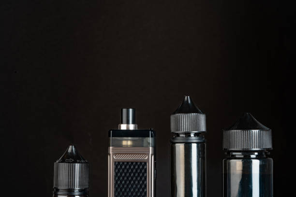 istock Vape and vape liquid bottles against black background 1644232047