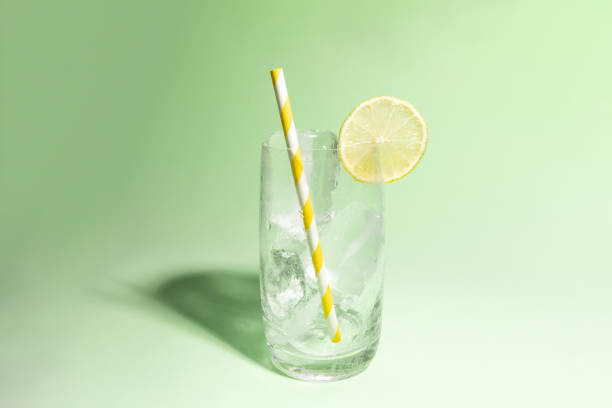istock Cold glass full of ice with a lime slice on green background with cast shadow. 1644256258
