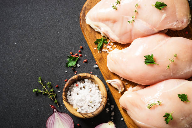 istock Chicken breast with spices at black background. 1644266867